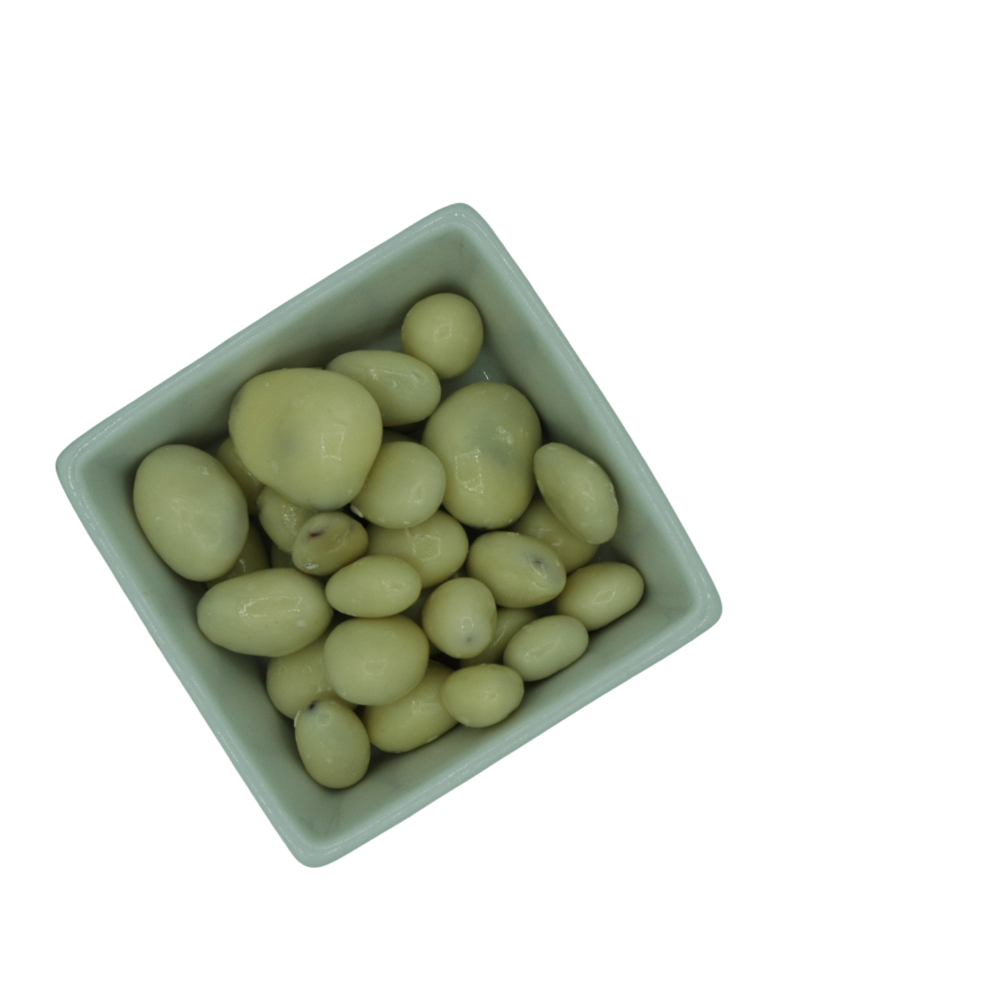 White ceramic bowl filled with white yoghurt covered dried fruit on a white background