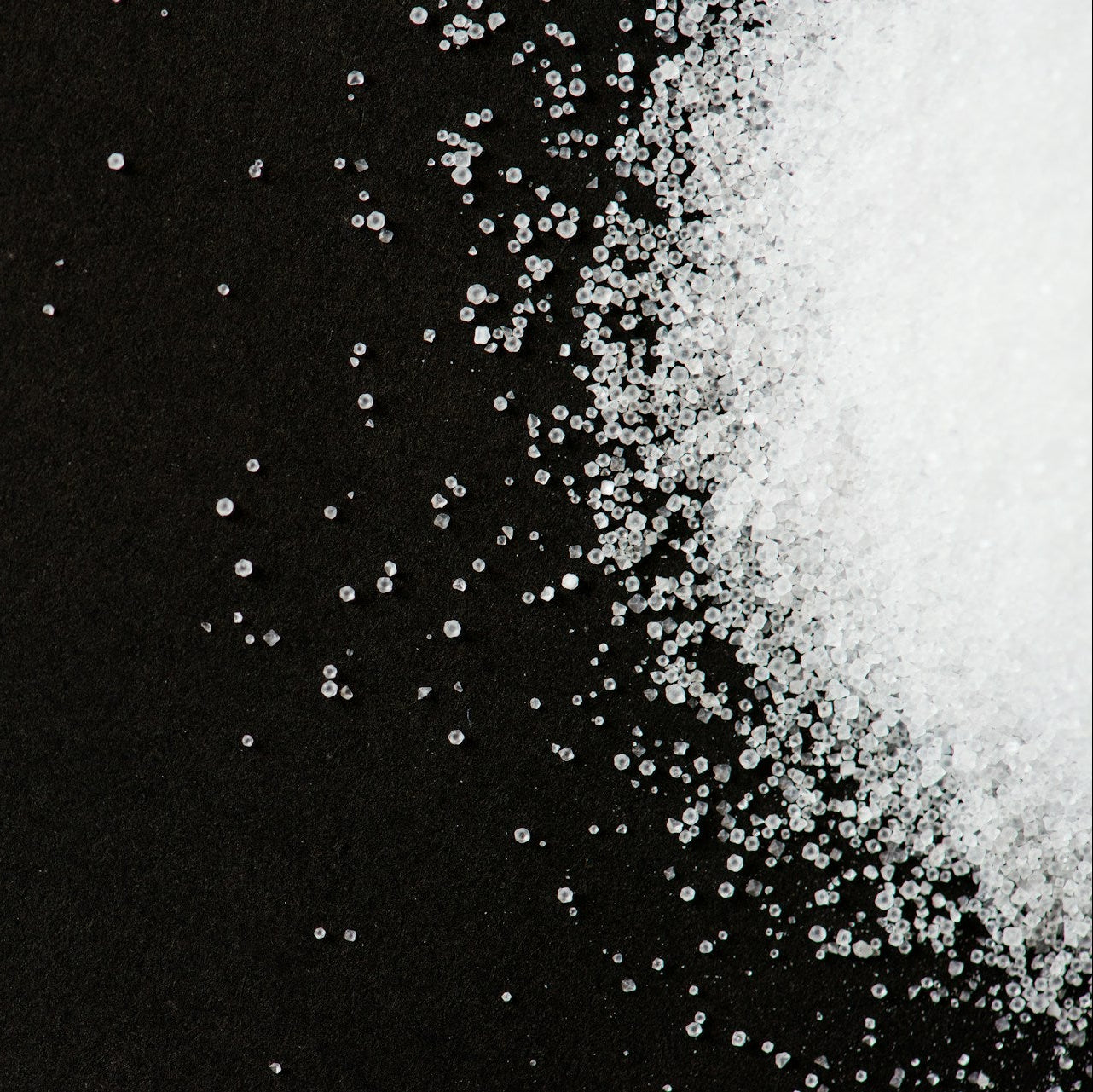White sugar crystals on a black background