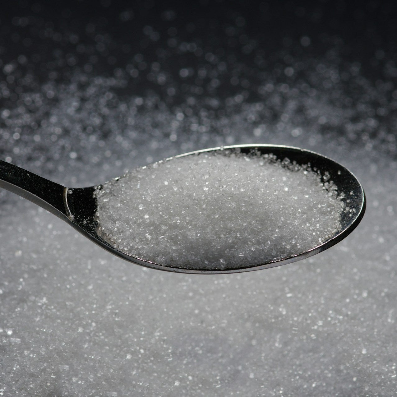 Spoonful of sugar on a dark background