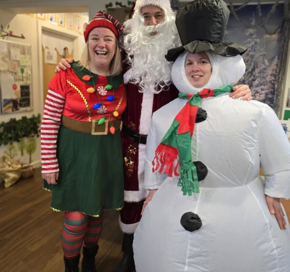three adults dressed in christmas costumes