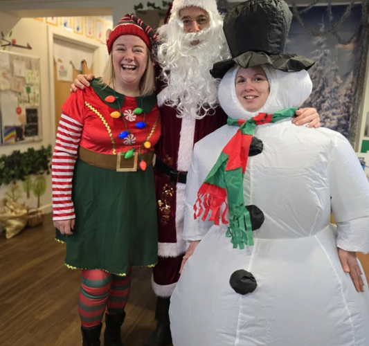 three adults dressed in christmas costumes