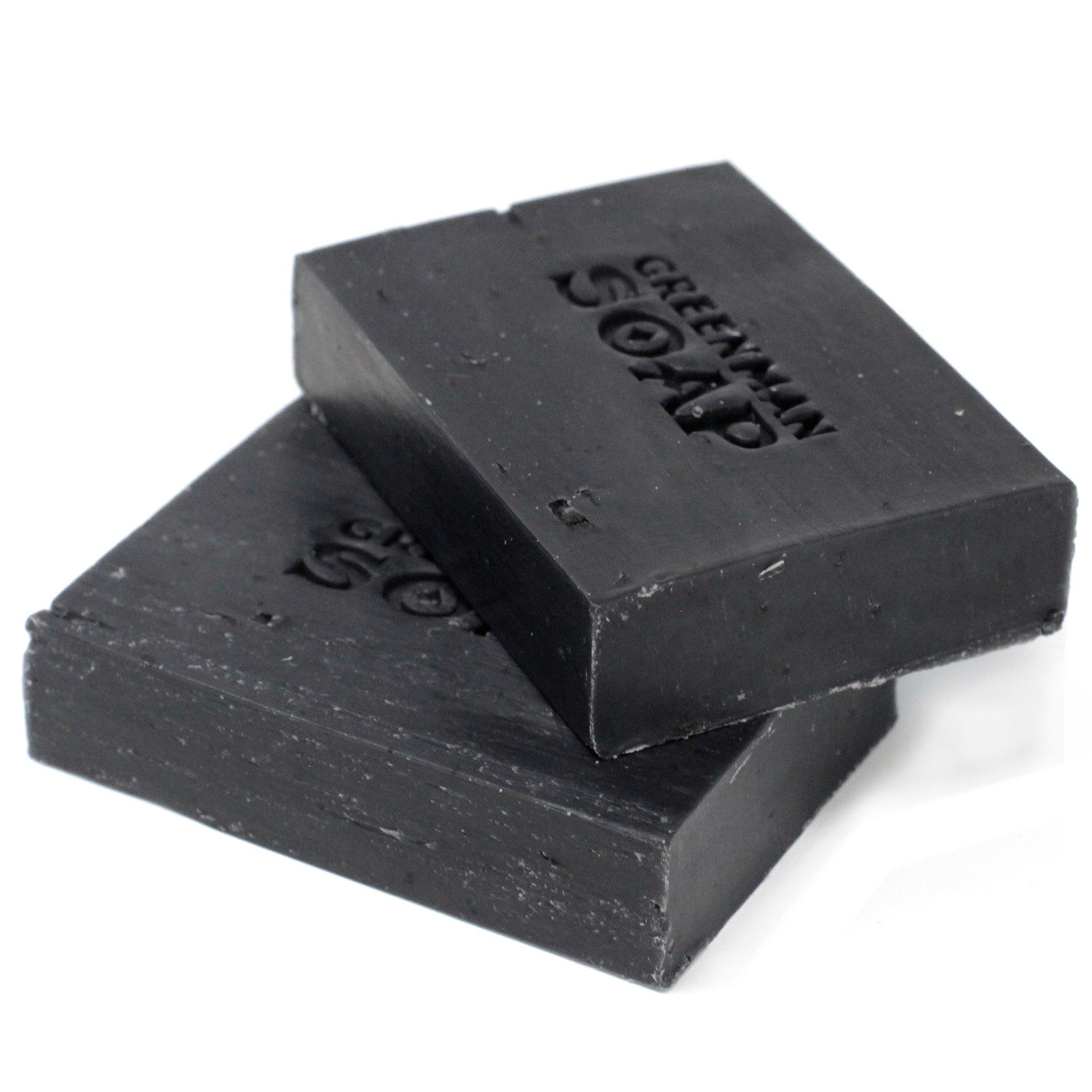 Two bars of black soap stacked on a white background with 'Greenman Soap' branding.