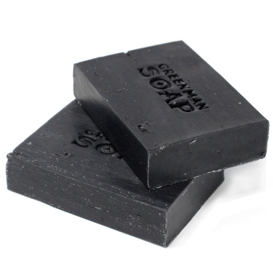 Two bars of black soap stacked on a white background with 'Greenman Soap' branding.