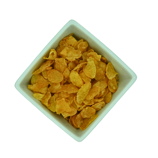 White bowl filled with yellow cornflakes on a white background