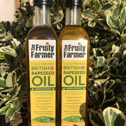 Two bottles of 'The Fruity Farmer' rapeseed oil with a leafy green background
