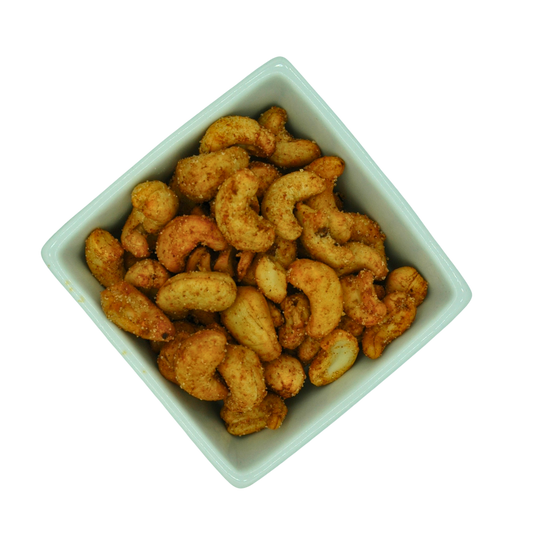 White bowl filled with roasted cashews on a white background