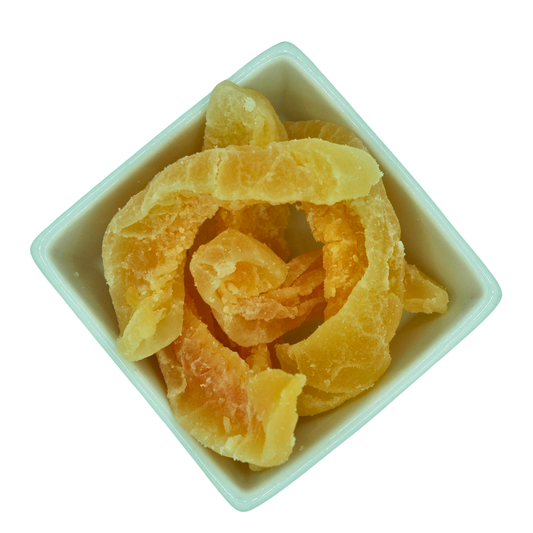 Dried cantaloupe melon chunky slices in a white bowl on a white background