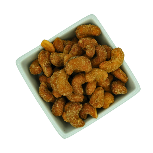 White bowl filled with roasted honey glazed chilli cashews on a white background