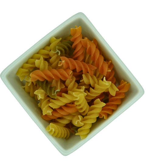Colorful fusili pasta in a white bowl on a white background