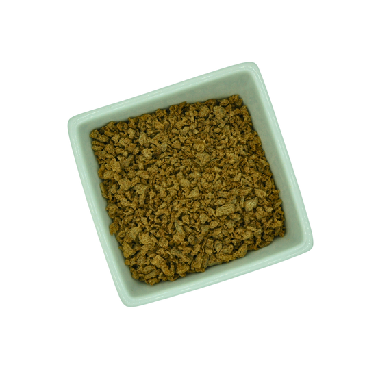 Square white bowl filled with dried tvp mince on a white background