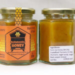 Two jars of honey with labels on a white background
