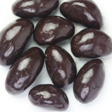Dark chocolate-covered almonds on a white background