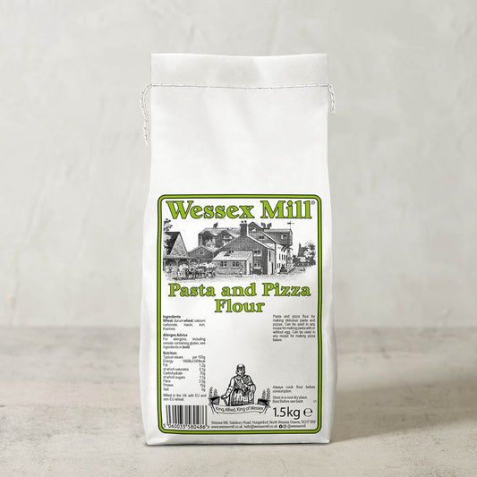 A 1.5kg white bag of Wessex Mill Pasta and Pizza Flour, featuring a green and black label with an illustration of a historic mill building, set against a neutral light gray background.