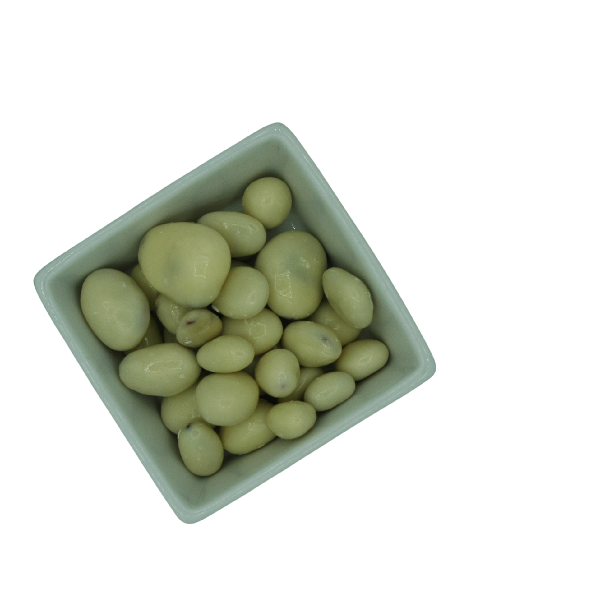 White ceramic bowl filled with white yoghurt covered dried fruit on a white background