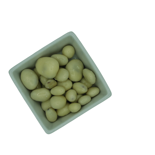 White ceramic bowl filled with white yoghurt covered dried fruit on a white background