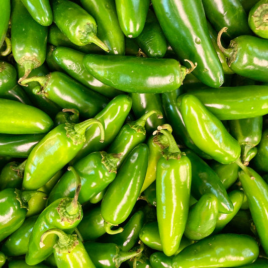 Close-up of a pile of green jalapeño peppers