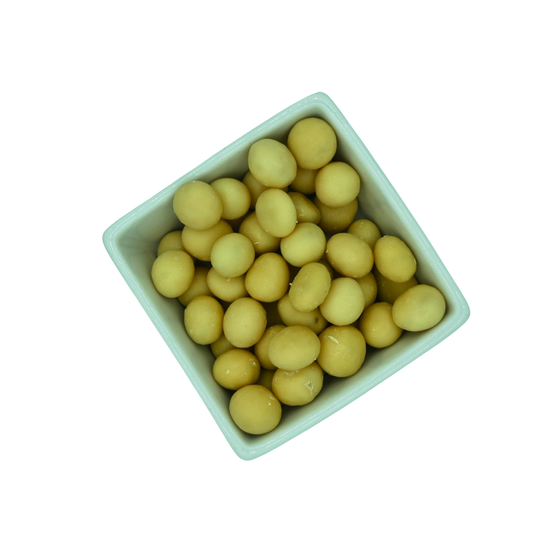 White bowl filled with yellow round yoghurt covered dried fruit on a white background