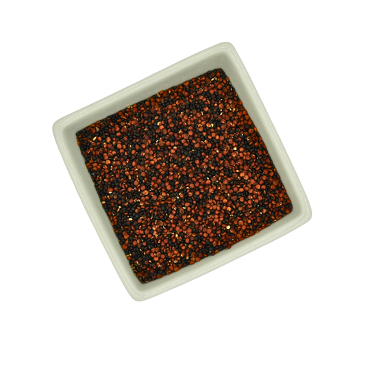 Square bowl filled with black and red speckled quinoa on a white background