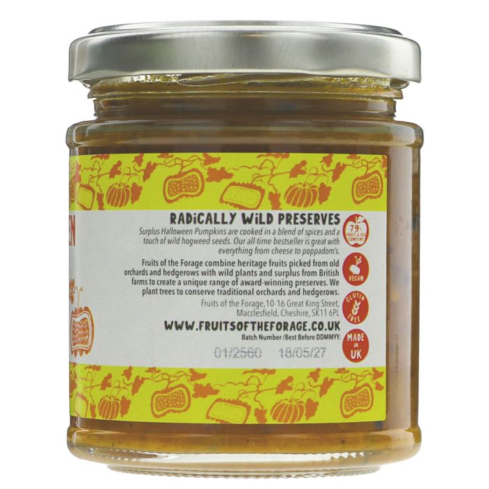 A glass jar of Radically Wild Preserves containing golden-brown pumpkin spread, sealed with a silver metal lid and featuring a yellow and white label with orange illustrations.