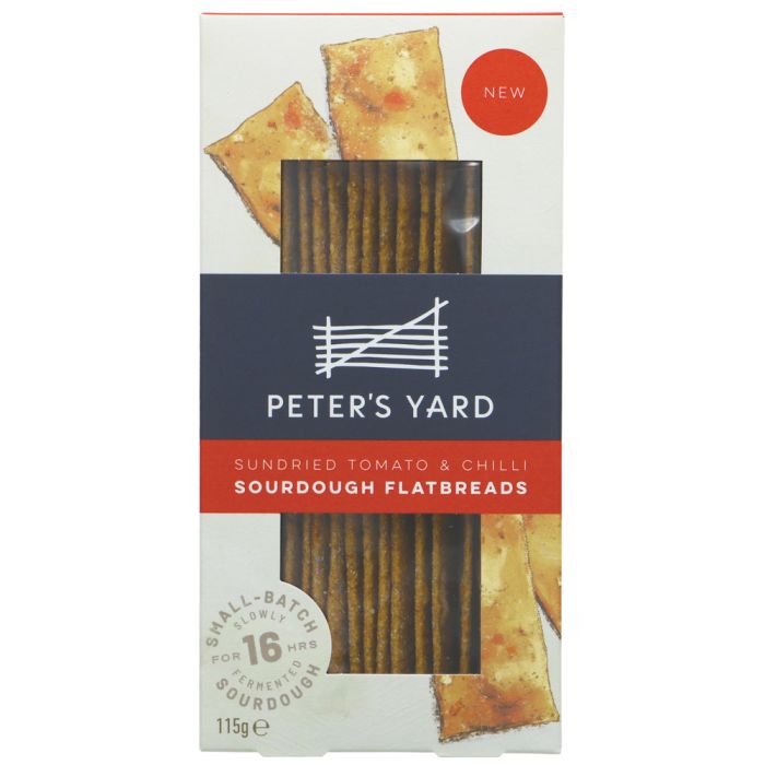 A package of Peter's Yard Sourdough Flatbreads, Sundried Tomato & Chilli, featuring a white box with a dark navy blue band and red accents, showing a clear window displaying the flatbreads inside.